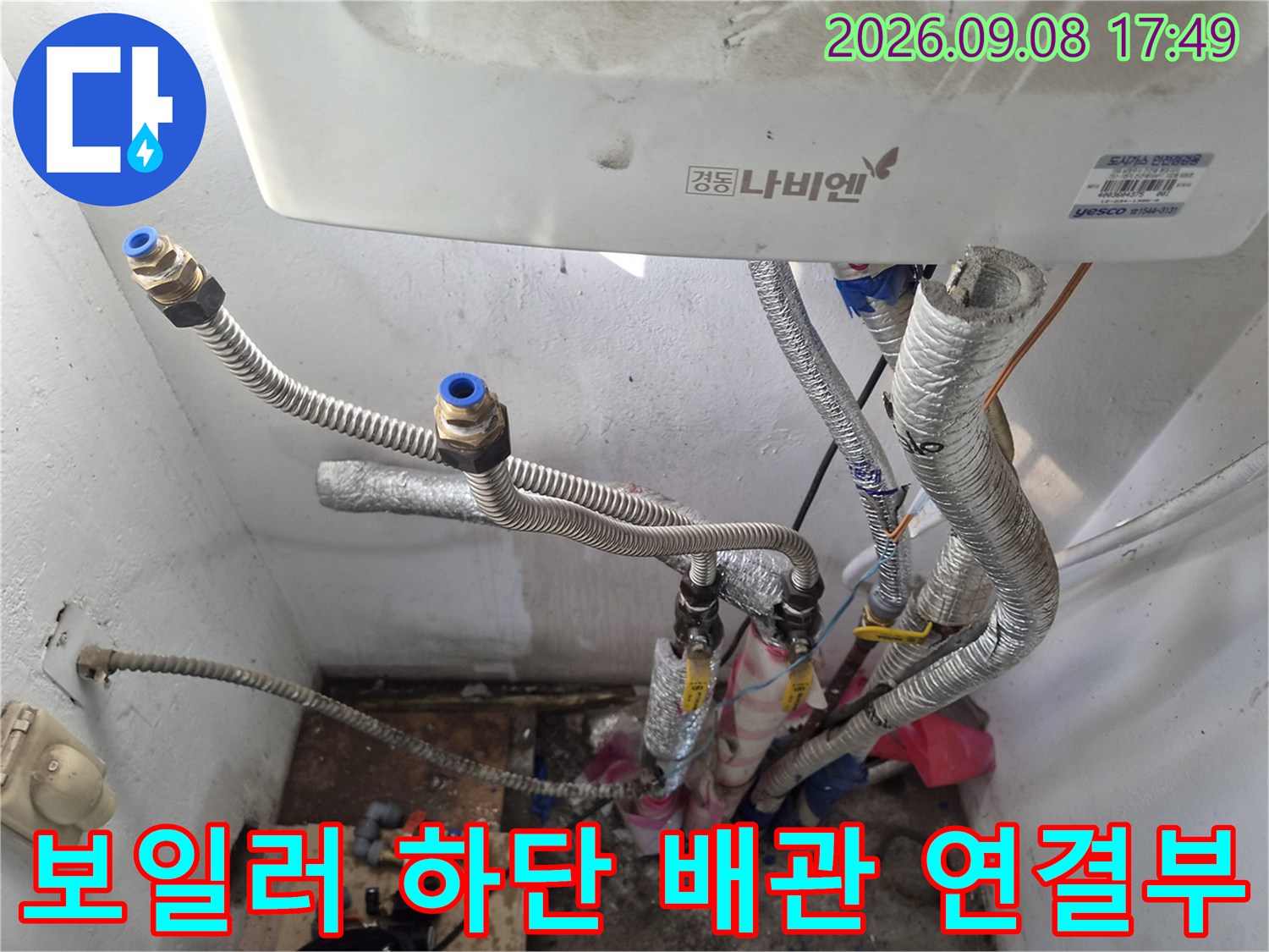 보일러-하단에-연결된-금속재질의-배관과-단열재-확인