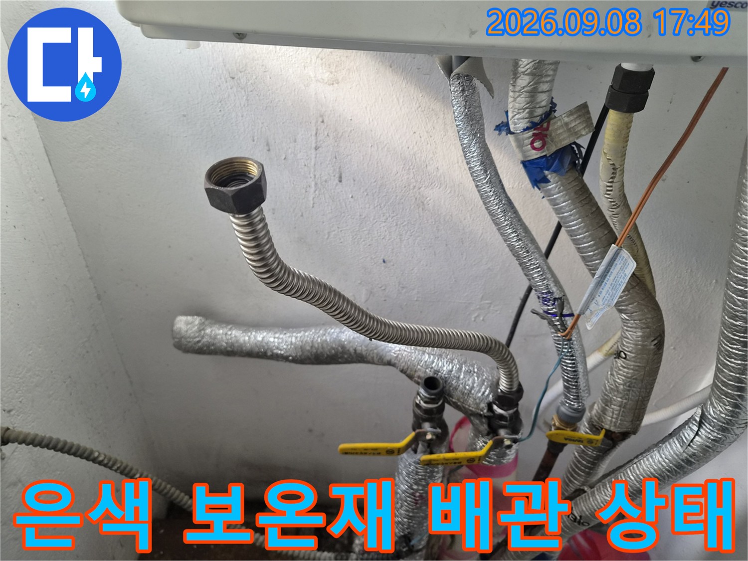 보일러실의 은색 보온재가 씌워진 배관들과 연결 부품들입니다.