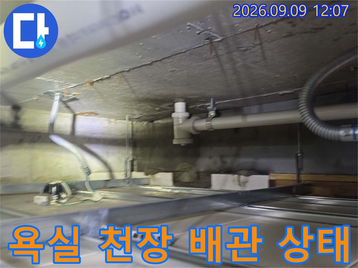 아랫집 욕실 천장 내부의 하수 배관과 연결 구조를 촬영한 사진입니다.