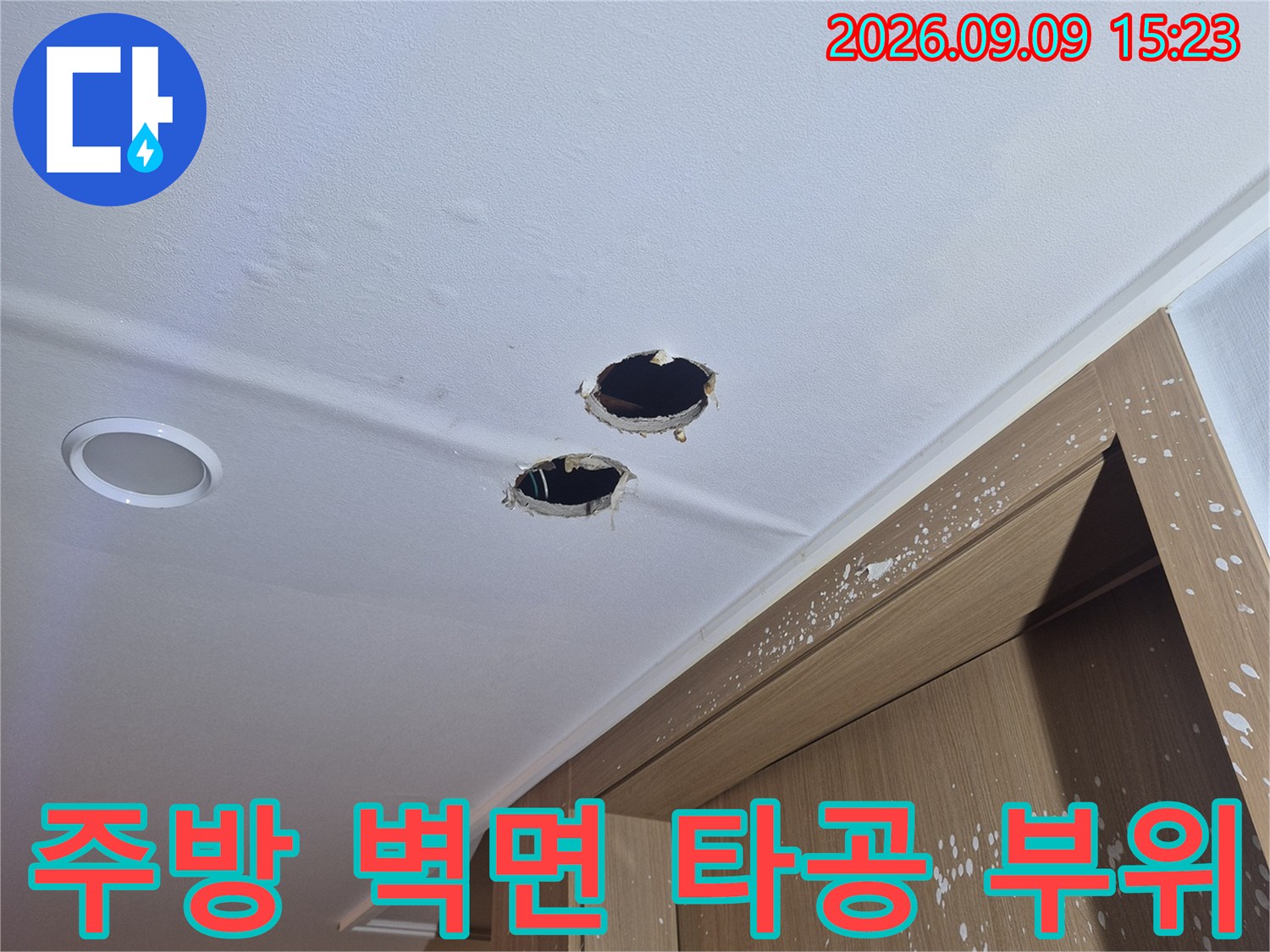 싱크대 하부장 근처 벽면에 위치한 배관 확인용 타공 구멍의 상세 모습입니다.