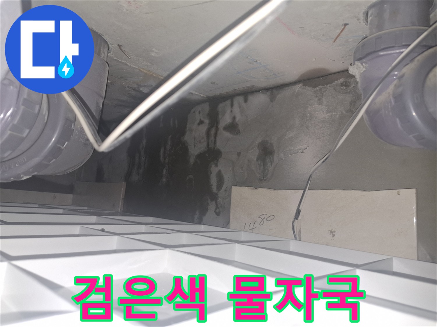 배관 하부 천장 - 습기가 스며들어 검게 변한 콘크리트 벽면 모습