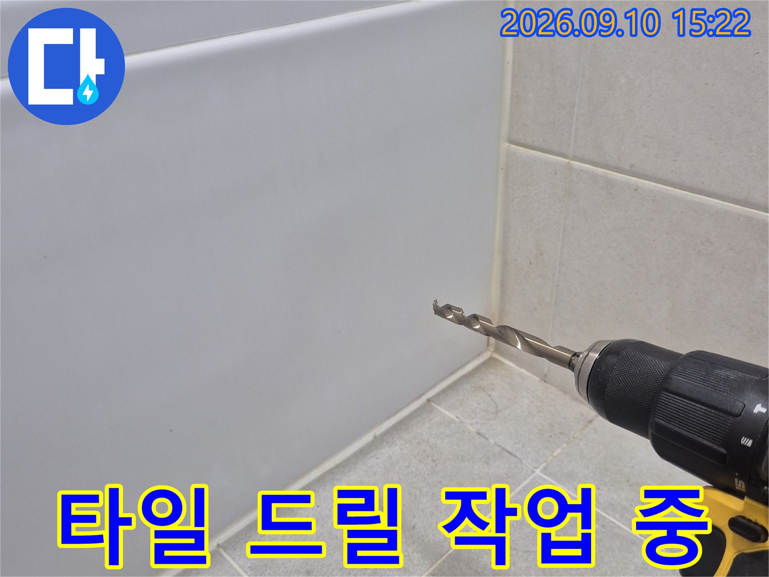 전동 드릴로-화장실 타일 끝부분을-정밀하게 타공하는 모습