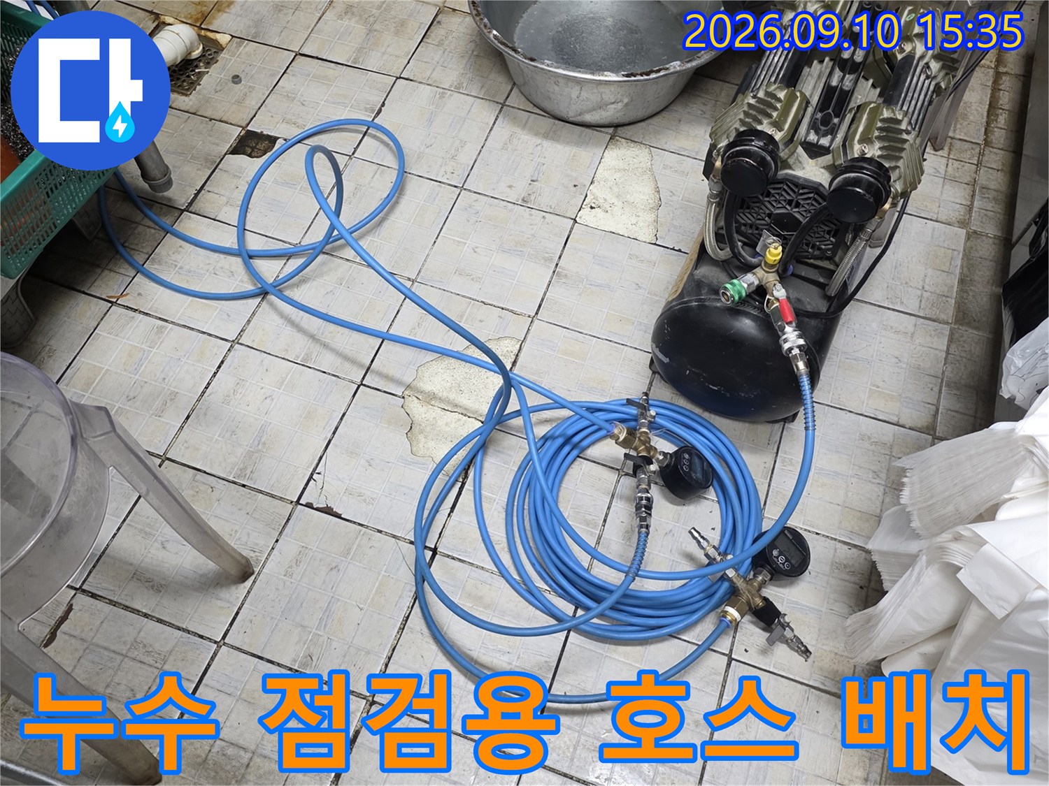 바닥 타일 위로 길게 연결된 파란색 공압 테스트 호스