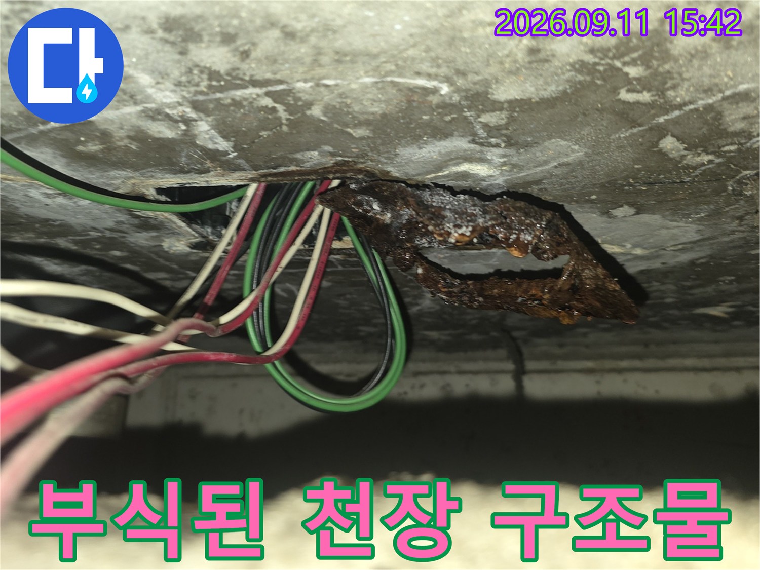천장 슬라브 부근의-심하게 부식된 금속판과 전기 배선들