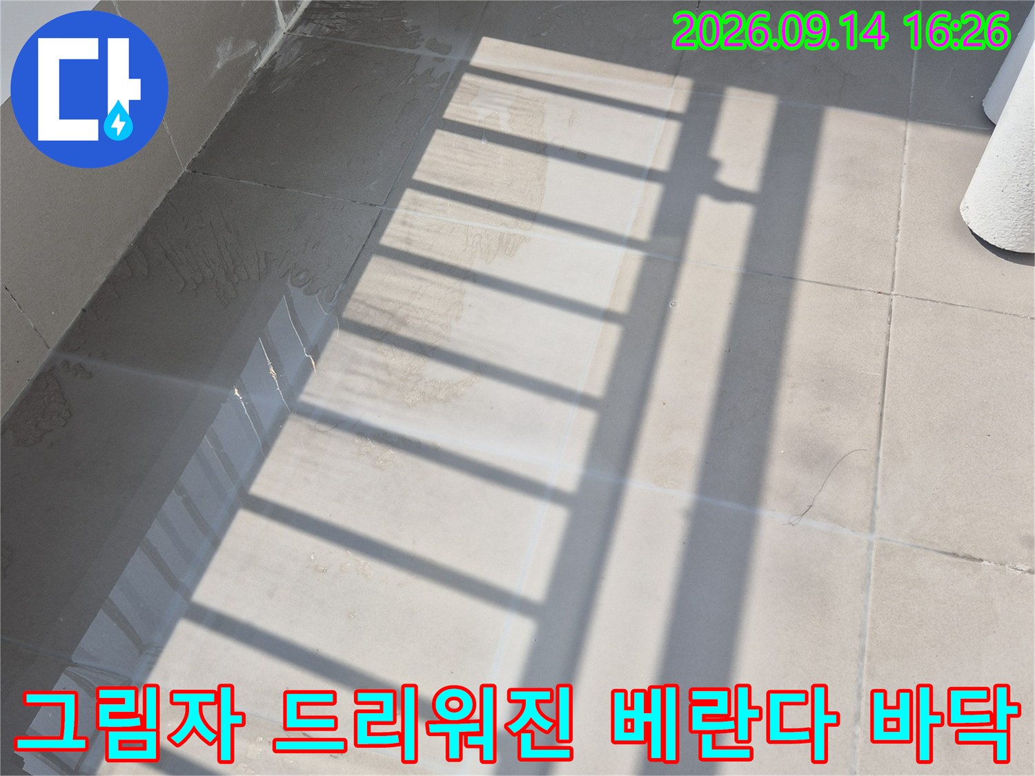 난간 그림자가 비치는 깔끔한 베란다 타일 바닥