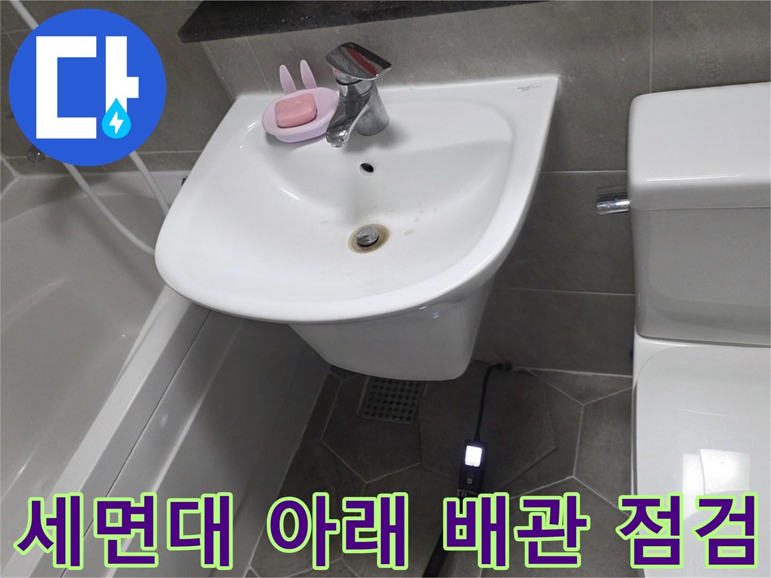 세면대 하단-바닥 배관 주변의 상태를 확인하는 모습