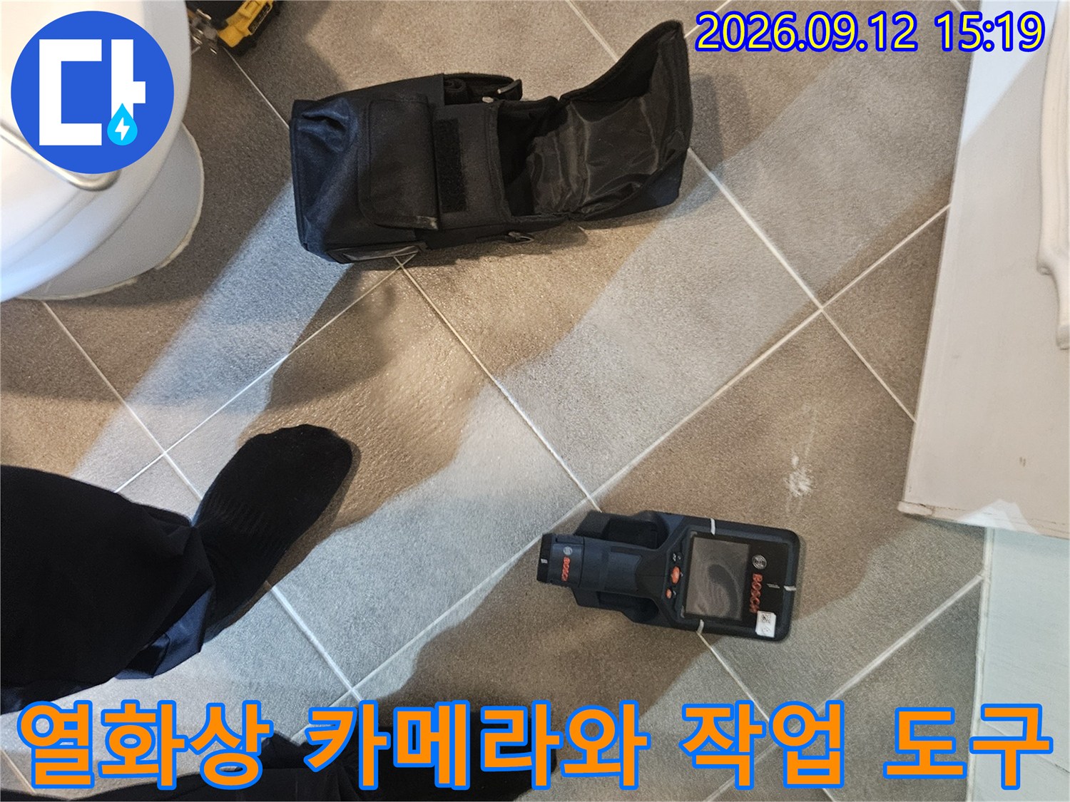 바닥 타일 위에 준비된 열화상 측정기 및 검사 가방
