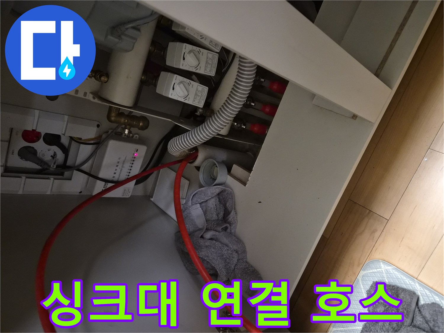 싱크대 아래 배수 관로와 밸브 장치 근접 사진
