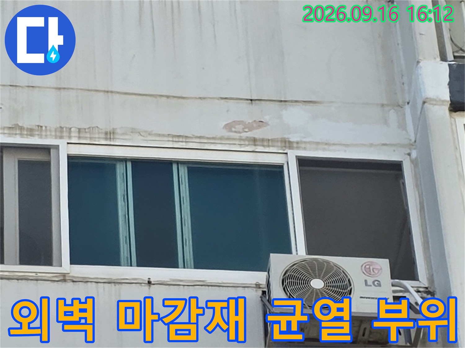 아파트 외벽의 창틀 상단 부분이 갈라지고 마감재가 떨어져 나간 모습입니다.