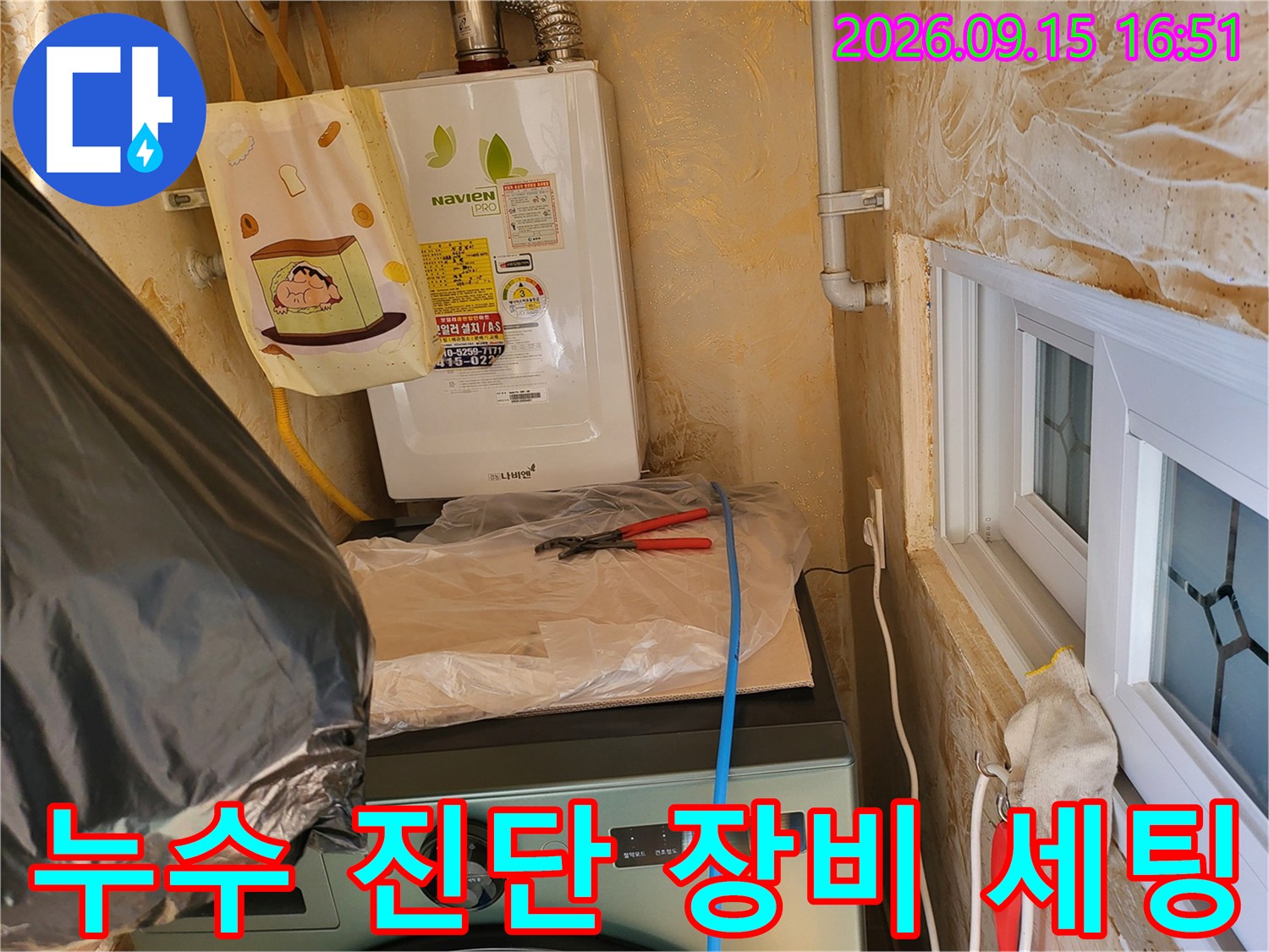 보일러실 배관에 연결된 압력 측정용 호스와 가스 탐지 준비 상태입니다.