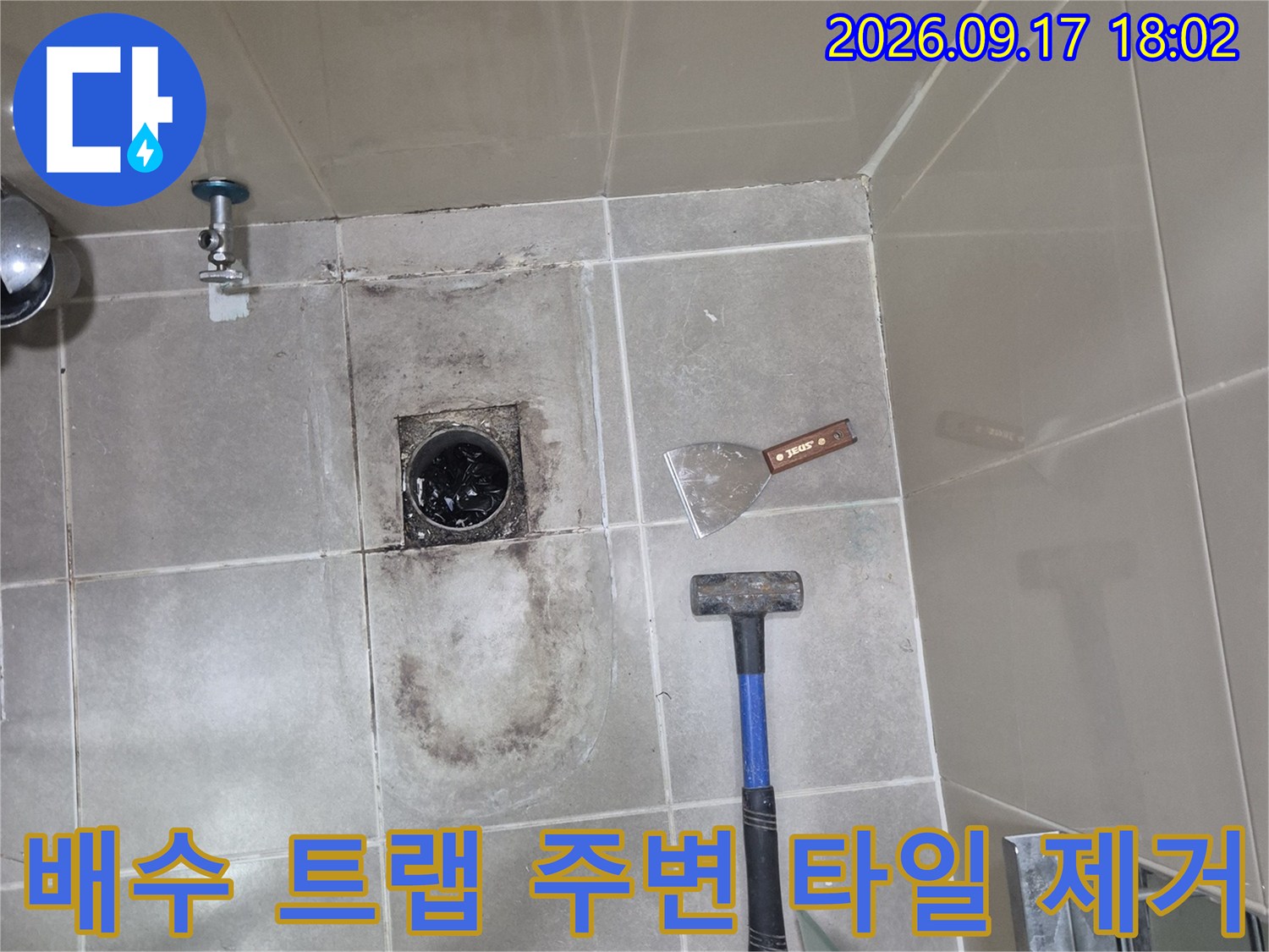 공사를 위해 망치와 헤라를 사용하여 배수구 주변 타일을 걷어낸 모습입니다.