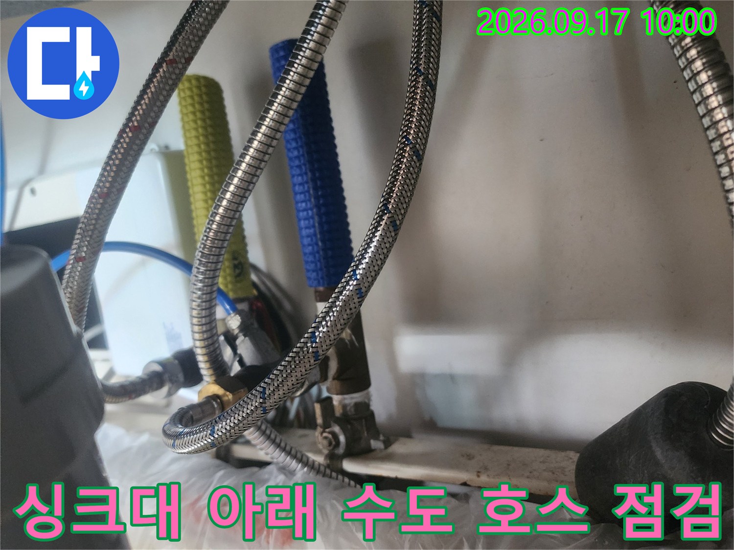 은색 메탈 호스와 파란색 튜브가 복잡하게 연결된 배관 구조입니다.