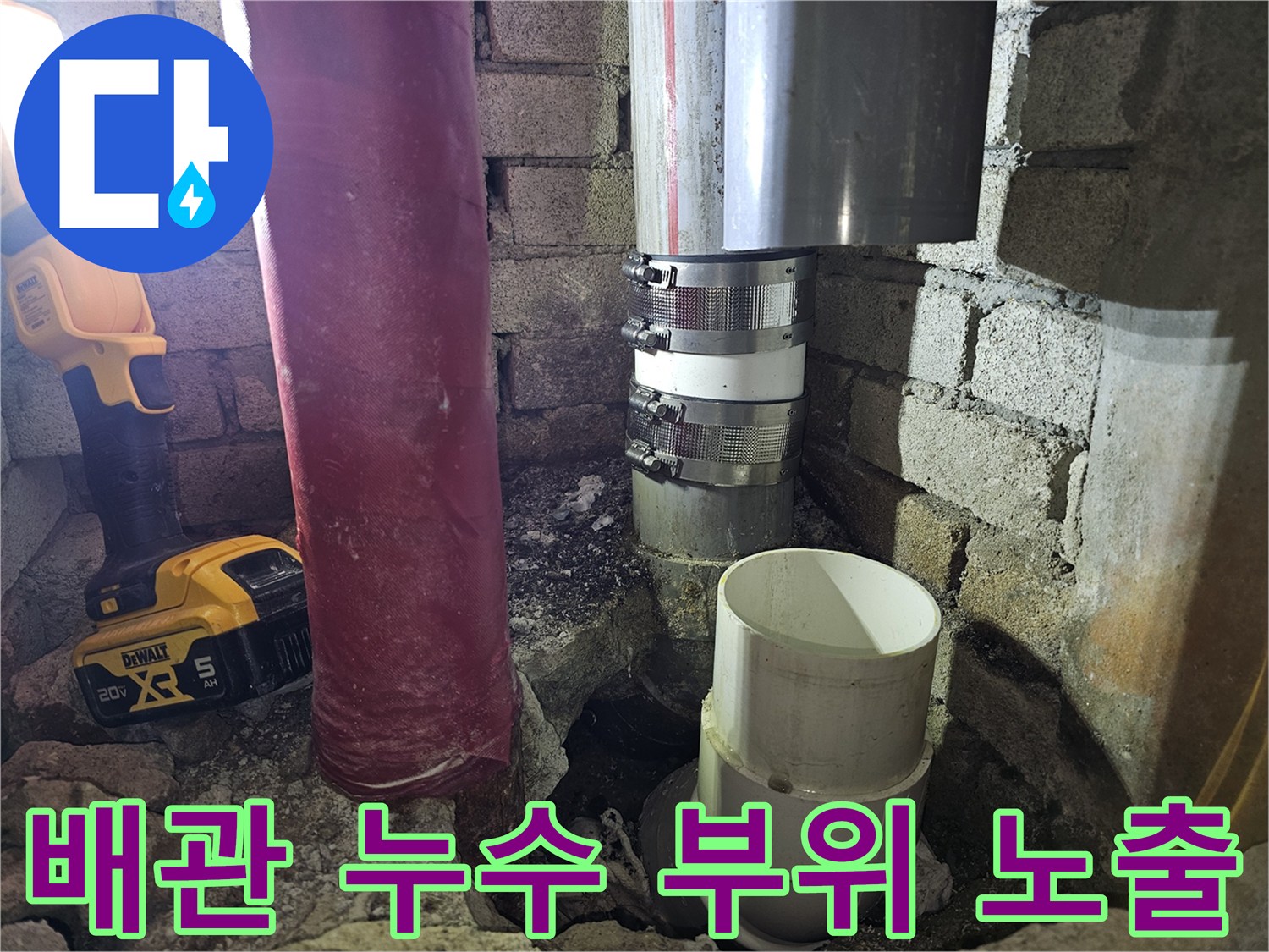 벽면 굴착 후 드러난 배관 연결부와 작업용 랜턴의 빛