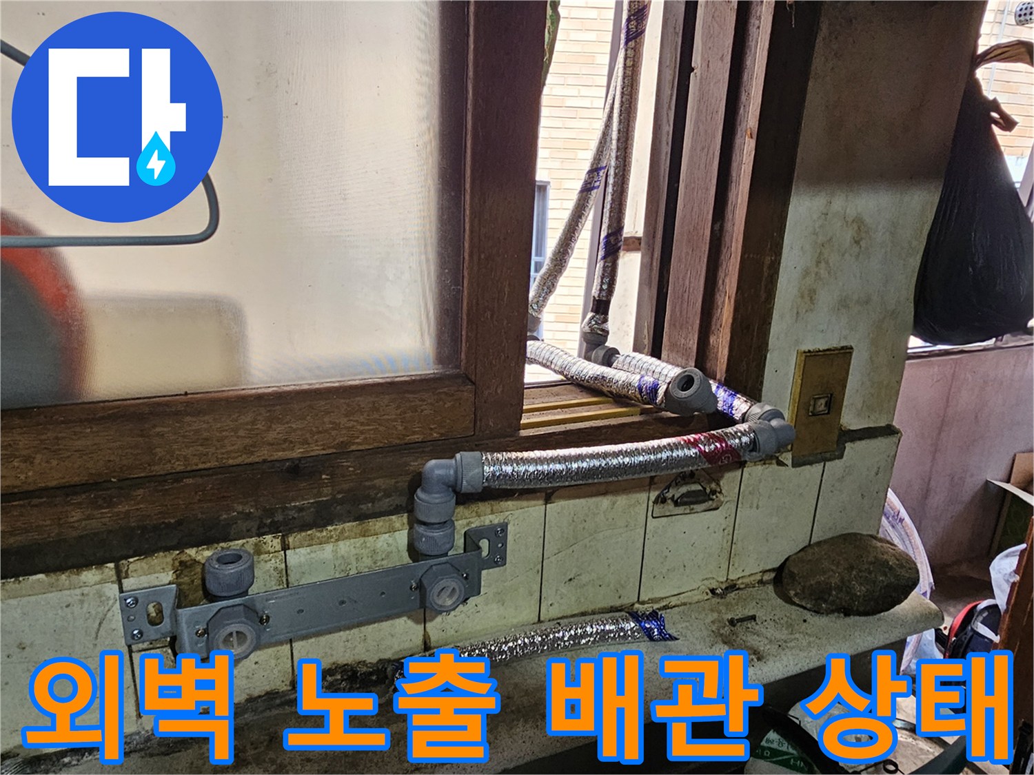 강동구 길동 현장의 외벽에 설치된 노출 배관과 연결 부위의 불량한 상태를 보여주는 사진입니다.